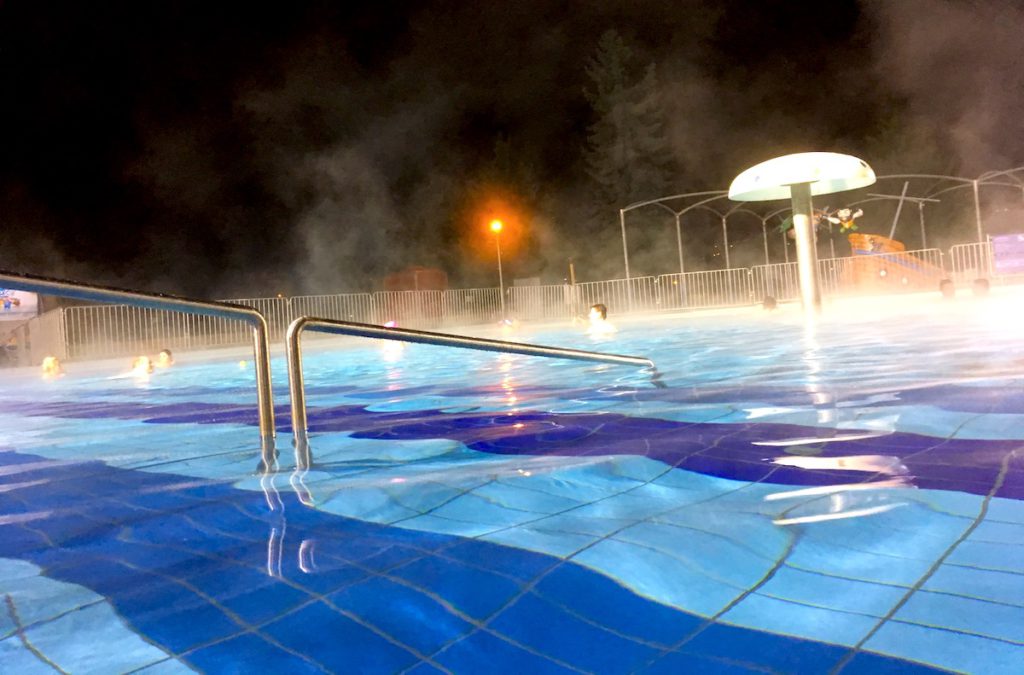 The outdoor thermal pool steaming on a winter evening